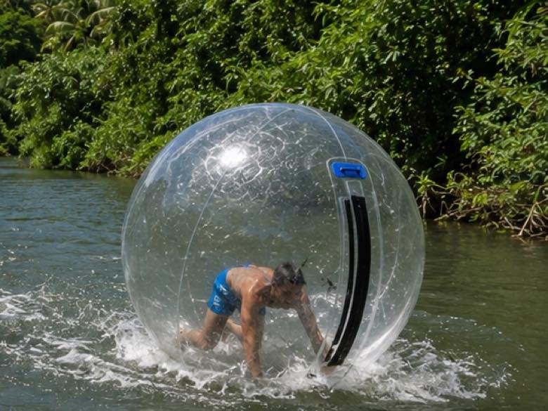 A guest scrambling to stay upright inside a water walking ball